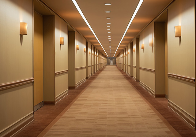 An elegant hotel corridor bathed in warm light, leading guests to their rooms and creating a welcoming atmosphere.