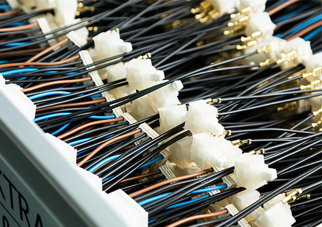 A wide range of cables and connectors demonstrates the precision engineering behind industrial lighting solutions and sensor technology.