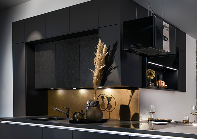 A modern black kitchen with stylish touches and indirect lighting, creating an elegant atmosphere.