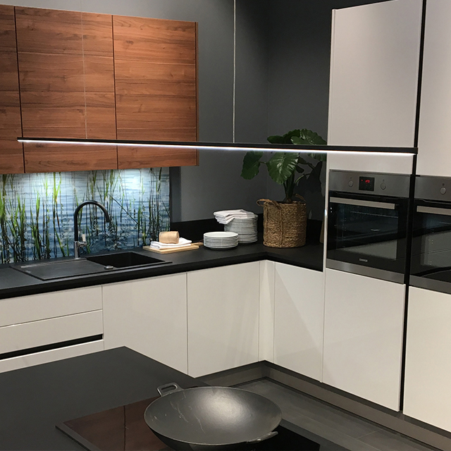 A modern kitchen with elegant lighting, wood panelling and stylish appliances, creating a welcoming atmosphere.