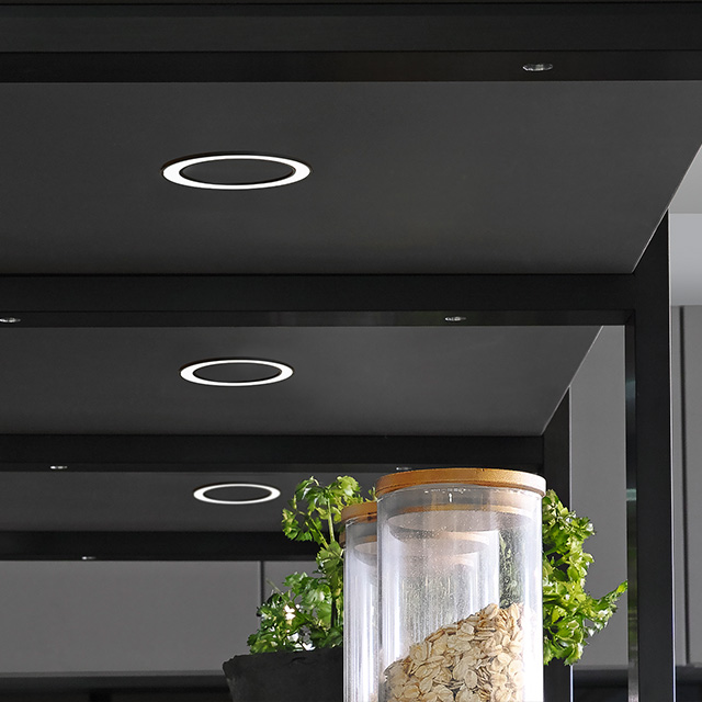 A modern shelf featuring round LED lights and a glass container housing a plant sets the tone for the stylish ambience.